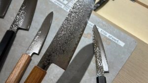 Comparing Damascus and hammered santoku knives at the JIKKO store in Kappabashi, Tokyo